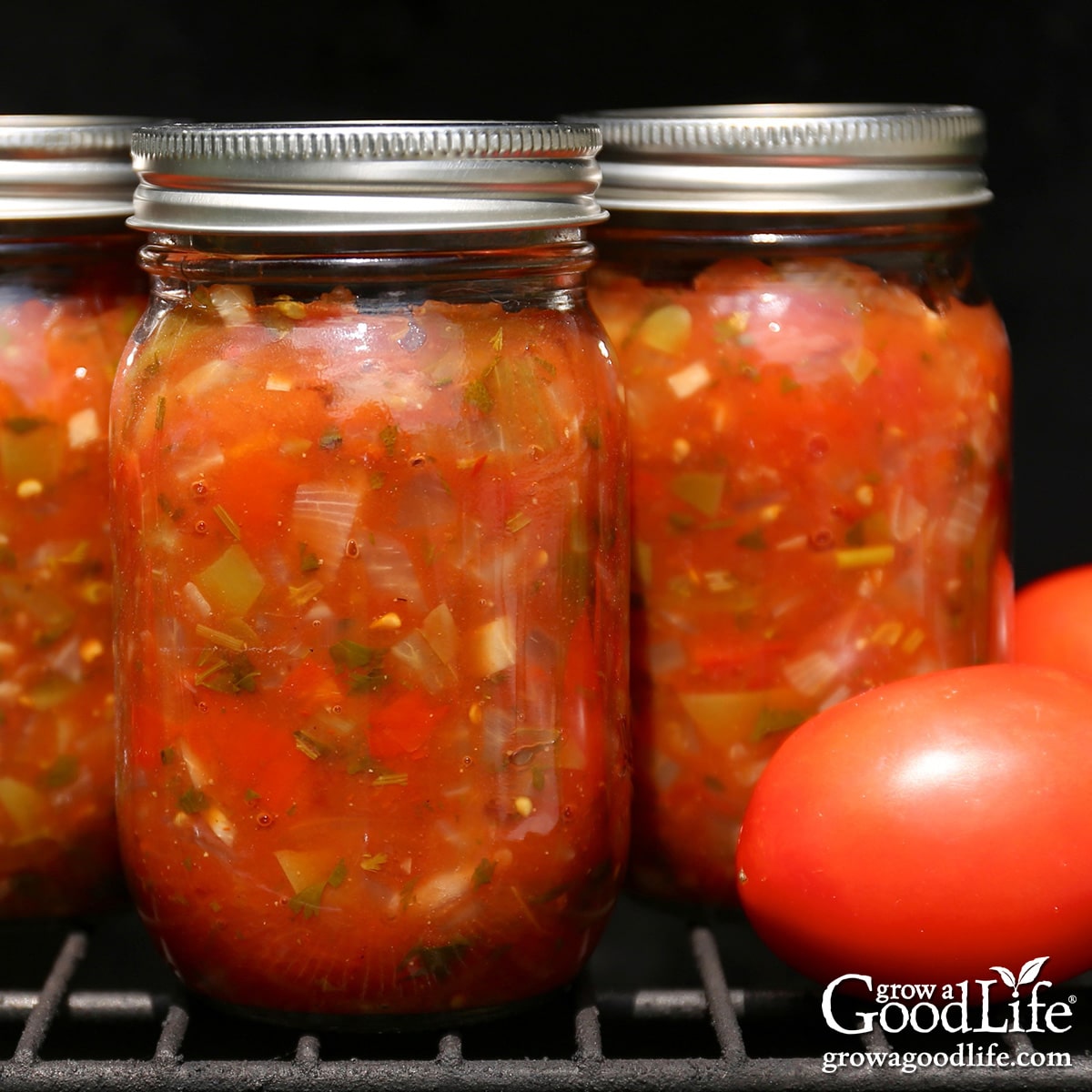 Pint jars of salsa on a gas grill.