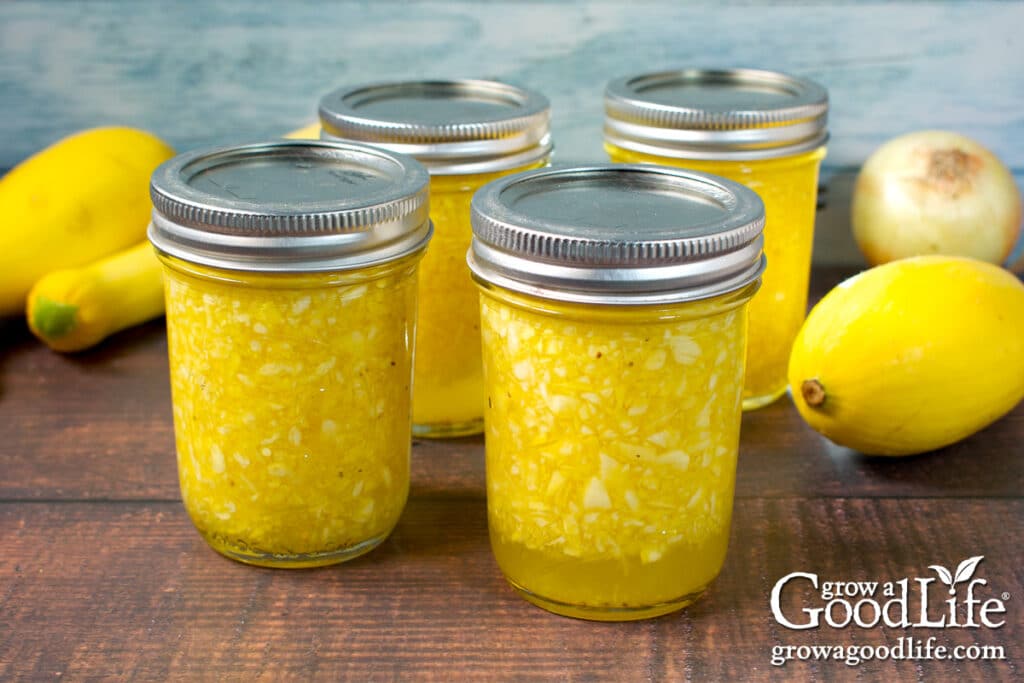 4 jars of home canned yellow summer squash relish on a table.