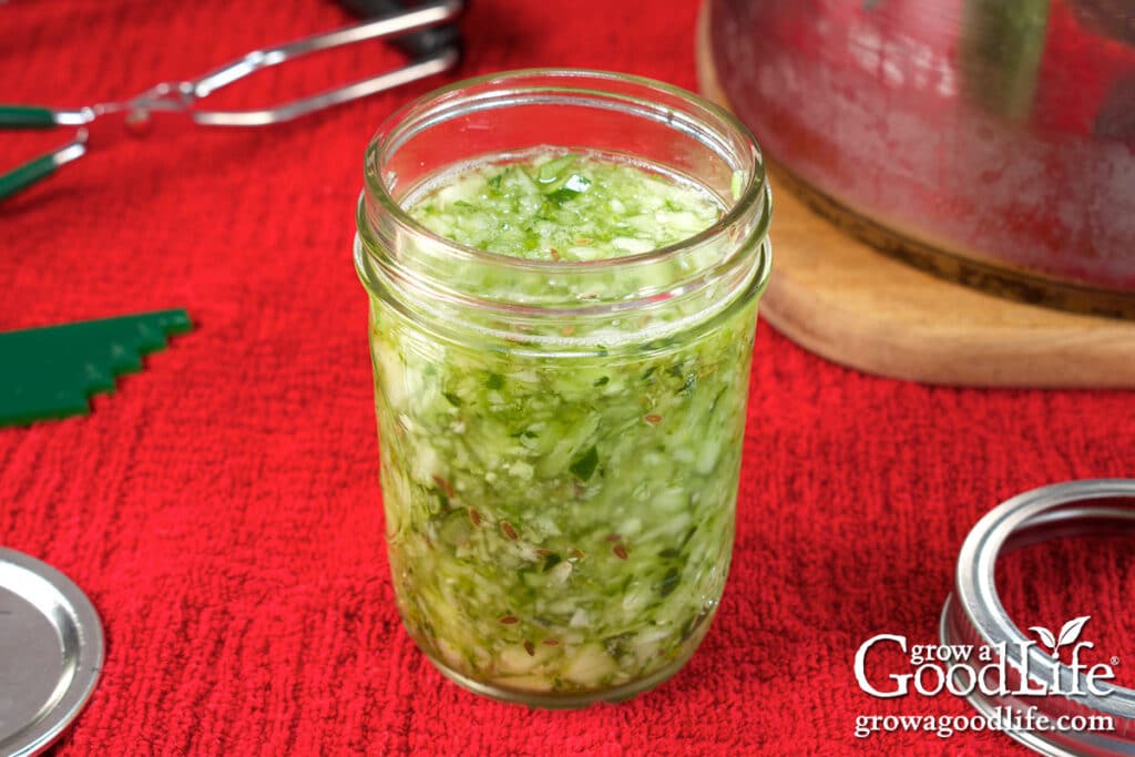 Filling a canning jar with dill relish.