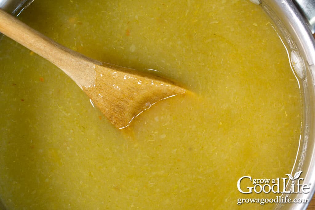 Green enchilada sauce simmering in a pot.