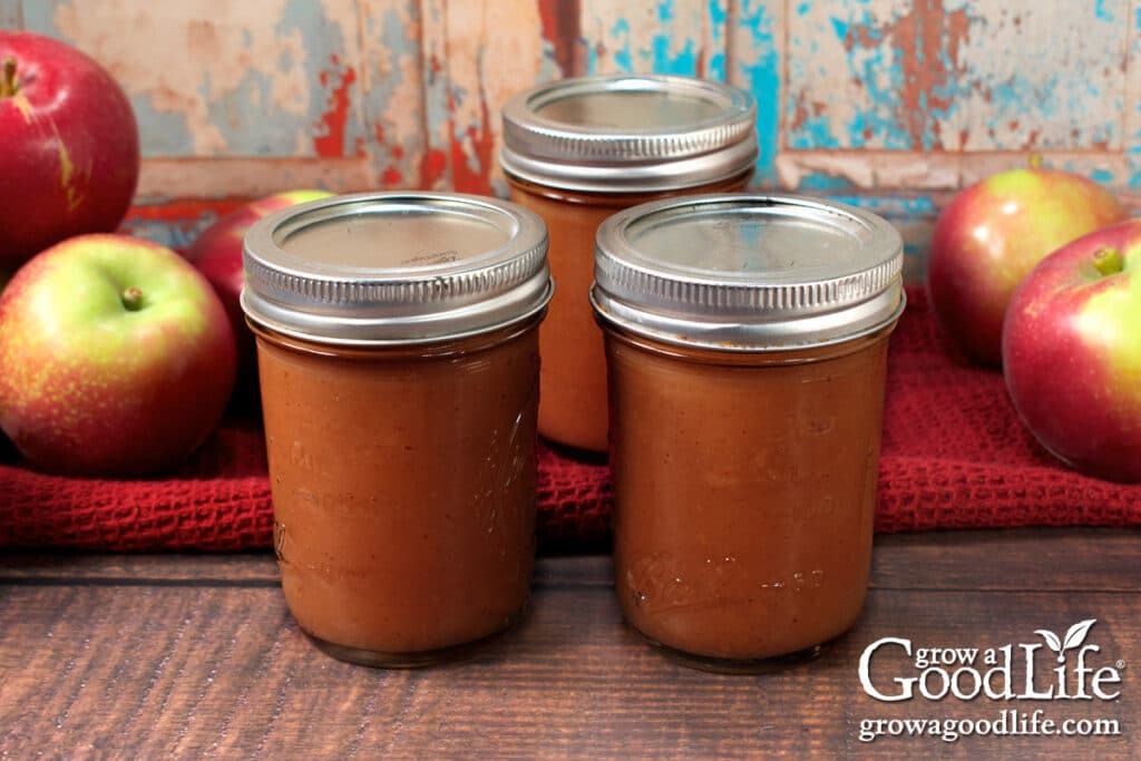 Jars of home canned apple butter on a table.