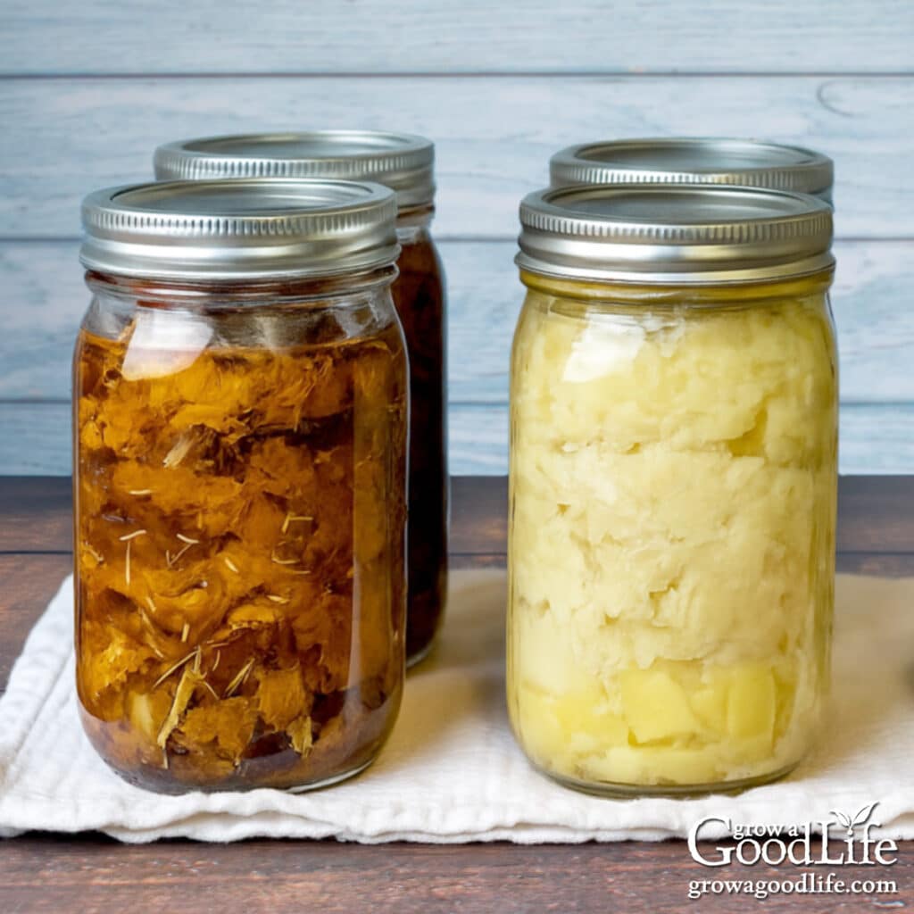 Quart sized jars of pressure canned beef and chicken on a table.