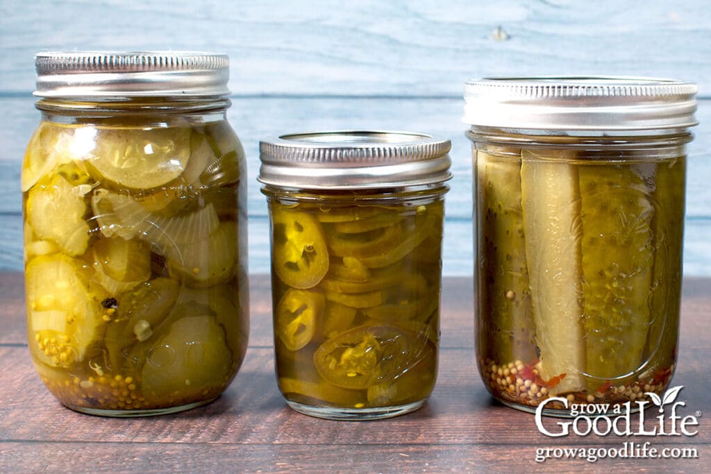 Jars of pickled cucumbers and jalapeños on a counter.