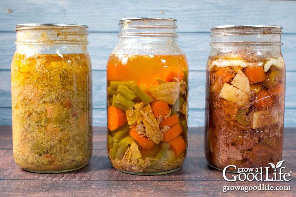 Three quart jars of home canned chicken chili, turkey soup, and beef pot roast on a table.