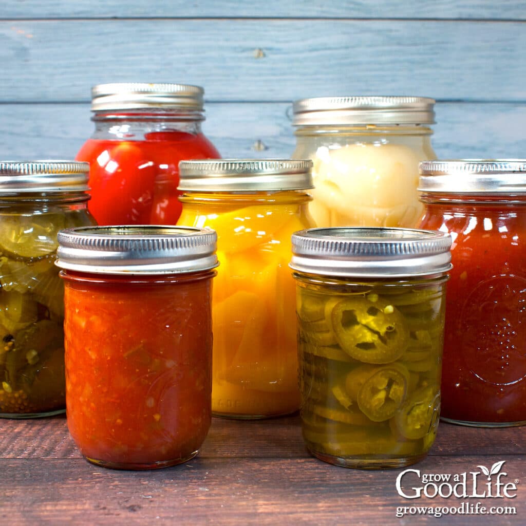 Jars of home canned food on a counter including quarts, pints, and half pints.