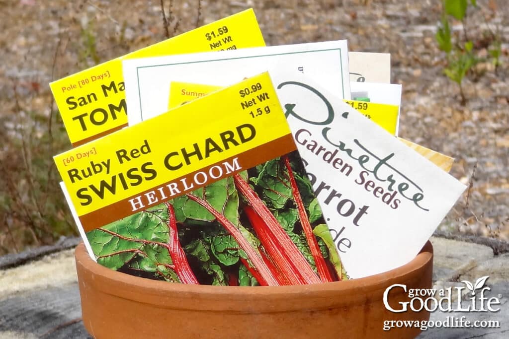 Close up of different seed packages displayed in a clay pot.