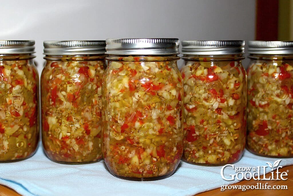 Pint sized jars of home canned spicy zucchini relish on a table.