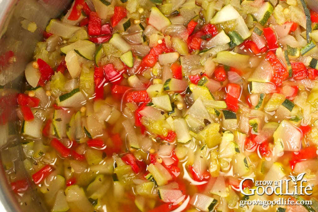 Close up of the prepared ingredients for spicy zucchini relish in a pot.