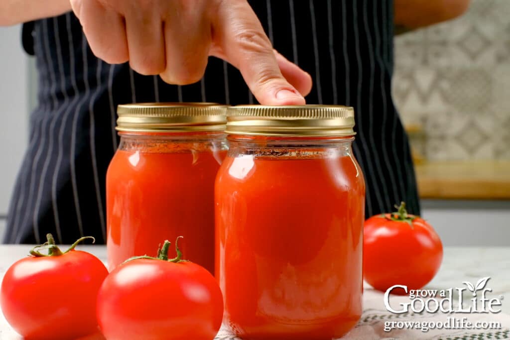 Pushing on the lid of the cooled jar to check the seal.