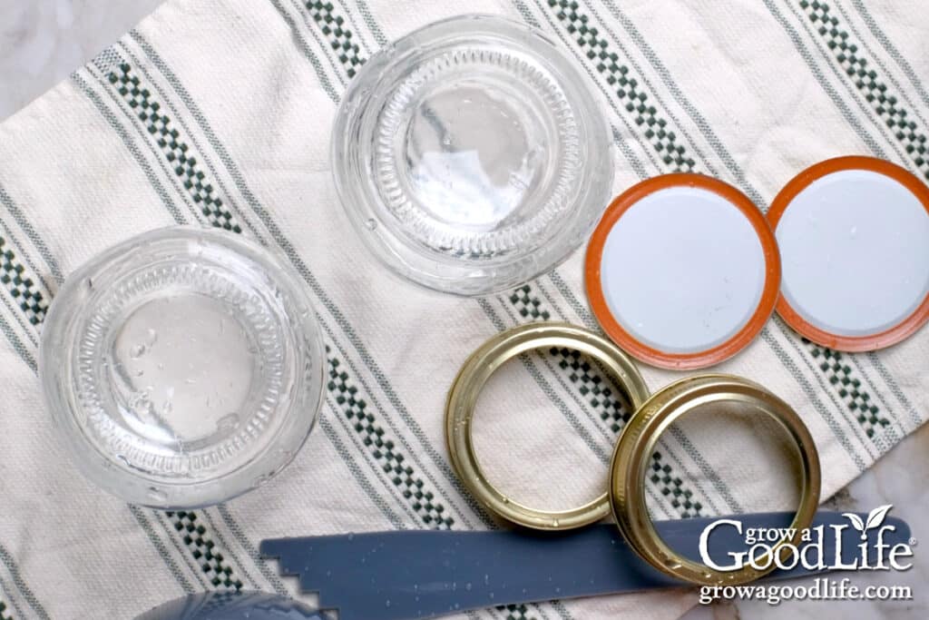 Washed canning tools and jars on a clean towel.