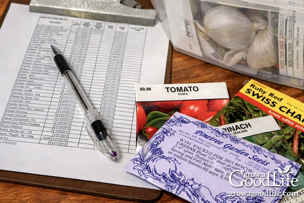 Creating a seed starting schedule on a kitchen table with seed packets, a calendar, and a planting chart.