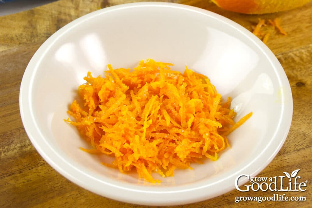 Grated orange zest in a small bowl ready to use in sweet and sour sauce.