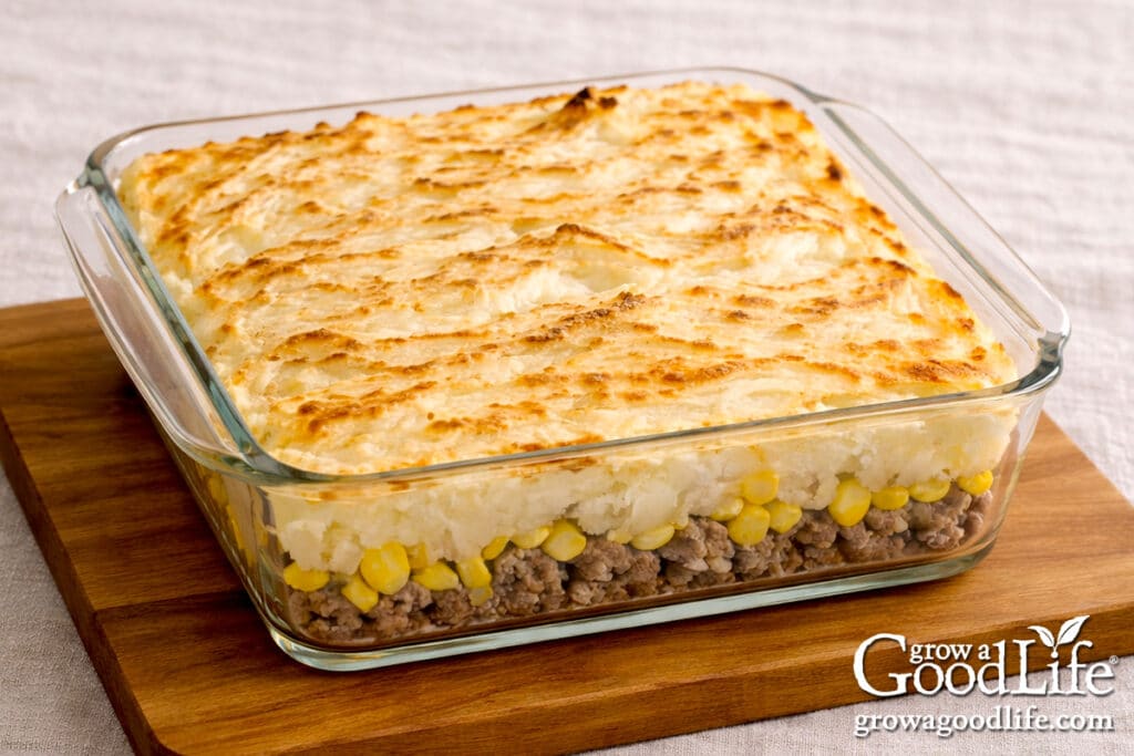 Baked pâté chinois in a square glass dish with golden mashed potato topping.