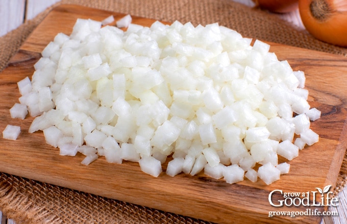 Chopped yellow onions on a cutting board ready to freeze.