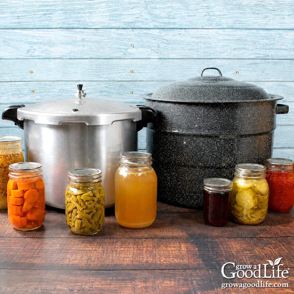Boiling water canner and pressure canner displayed side by side with jars of home-canned food.